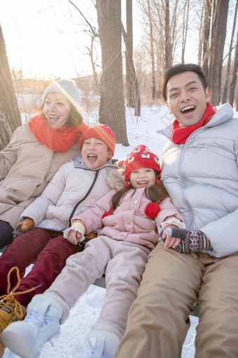 雪地里荡秋千的快乐家庭做游戏高质量相片