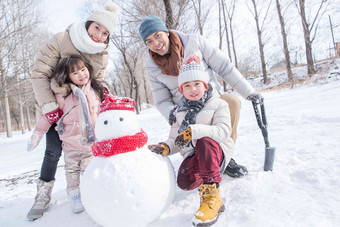 欢乐家庭在雪地里堆雪人彩色图片氛围摄影