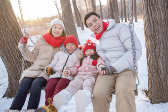 雪地里荡秋千的快乐家庭父亲氛围镜头