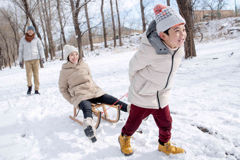 在<strong>雪地</strong>上玩雪橇的一家人摄影清晰素材