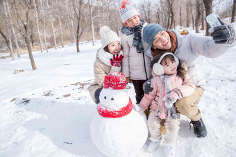 欢乐家庭在雪地里堆雪人