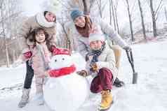 欢乐家庭在雪地里堆雪人