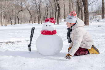 快乐的小男孩在雪地里堆雪人