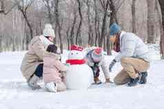 欢乐家庭在雪地里堆雪人