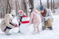 欢乐家庭在雪地里堆雪人