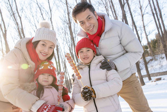 雪地里拿着糖葫芦的快乐家庭中国人高质量影相