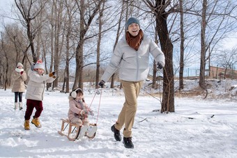 欢乐家庭在雪地上玩雪橇男孩氛围场景