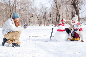 欢乐家庭在雪地里照相