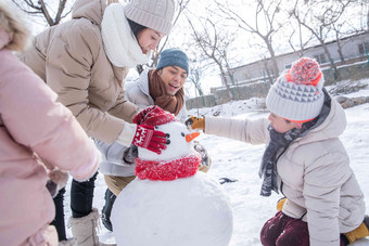 欢乐家庭在雪地里<strong>堆雪人</strong>水平构图高端相片