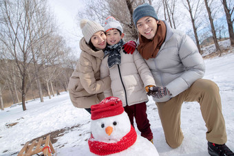 一家三口在雪地里<strong>堆雪人</strong>