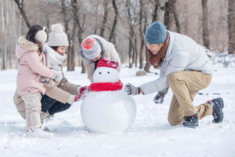 欢乐家庭在雪地里<strong>堆雪人</strong>