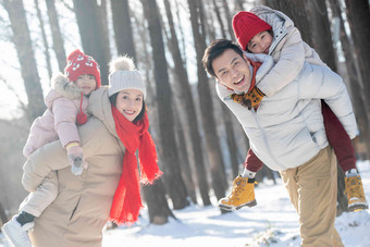 雪地里玩耍的快乐家庭背着照片