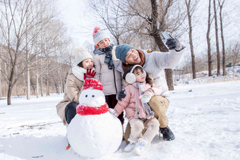 欢乐家庭在雪地里堆雪人幸福写实场景