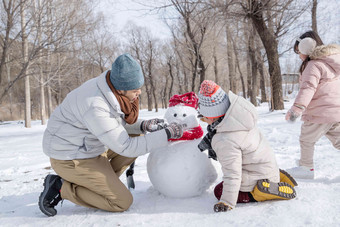 爸爸和孩子们推<strong>雪人</strong>