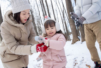 一家三口在雪地里玩耍人写实照片