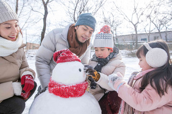 欢乐家庭在雪地里堆雪人