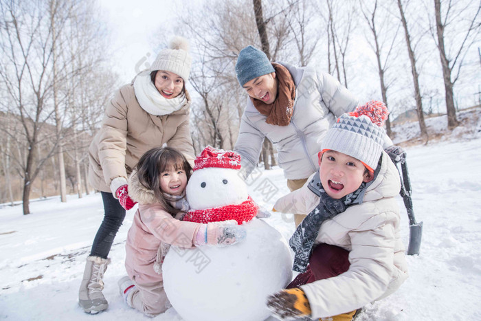 欢乐家庭在雪地里堆雪人中年人氛围镜头