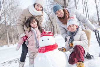 欢乐家庭在雪地里堆雪人