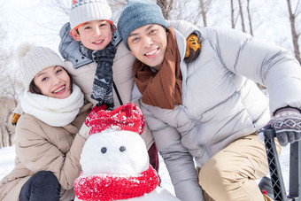 一家三口在雪地里堆雪人白昼高清照片