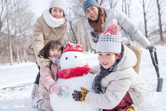 欢乐家庭在雪地里堆雪人母亲写实相片