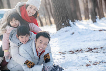 趴在雪地里玩耍的快乐家庭儿子氛围拍摄