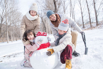 欢乐家庭在雪地里堆雪人