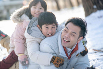 爸爸和孩子们在雪地里玩耍厚衣服摄影图