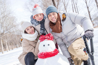 一家三口在雪地里<strong>堆雪人</strong>