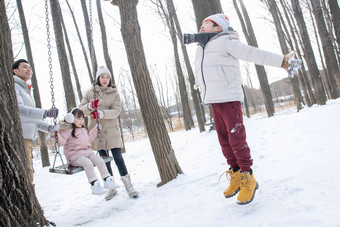 快乐的一家人在雪地里玩耍秋千素材