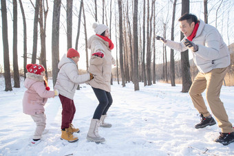 雪地里做游戏的快乐家庭水平构图氛围素材