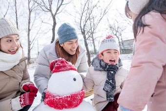 欢乐家庭在雪地里堆雪人雪人场景