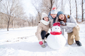 一家三口在雪地里<strong>堆雪人</strong>