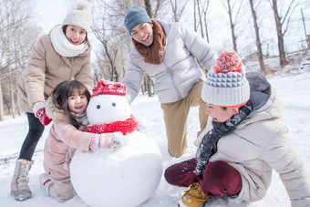 欢乐家庭在雪地里堆雪人夫妇高质量拍摄