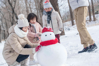 欢乐家庭在雪地里堆雪人