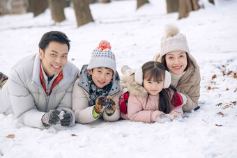 趴在雪地里玩耍的快乐家庭兄弟姐妹高端图片