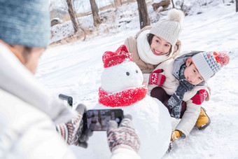 欢乐家庭在雪地里照相手机高质量影相