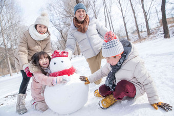 欢乐家庭在雪地里堆雪人儿子氛围场景