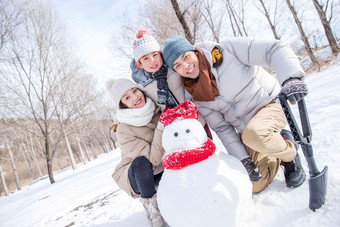 一家三口在雪地里<strong>堆雪人</strong>