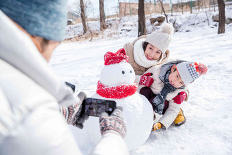 欢乐家庭在雪地里照相玩耍清晰摄影图