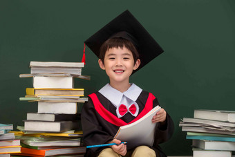 穿着学士服的小学男生教科书氛围影相