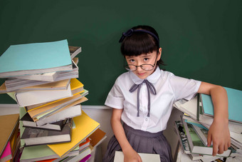 坐在书堆里的小学女生仅女孩写实场景