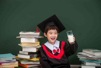 穿着学士服的小学男生坐着清晰相片