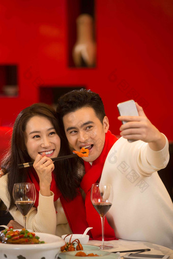 青年情侣用手机拍照喜庆氛围图片