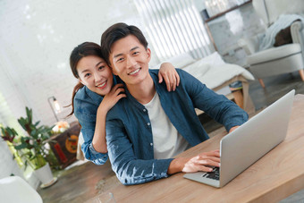 快乐的青年伴侣使用笔记本电脑青年人相片