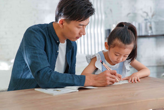 辅导女儿做作业的年轻爸爸家庭作业图片