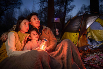 快乐的三口之家夜晚在户外露营东方人写实素材