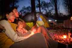 幸福的一家三口夜晚在野外露营青年女人清晰影相
