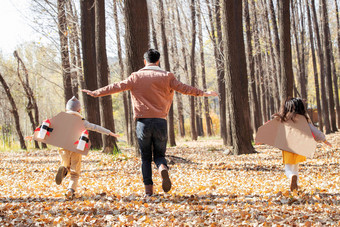 快乐的孩子们和父亲在户外奔跑的背影落叶氛围场景