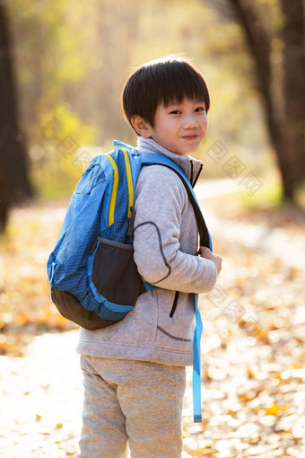 秋天户外小路上背<strong>书包</strong>的小男孩