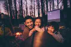 幸福的父亲和两个孩子夜晚野外露营女孩氛围摄影图